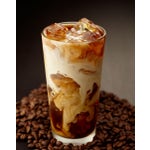 Cup of iced coffee sitting on top of coffee beans.