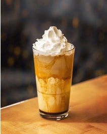 Blended coffee in a glass topped with whipped cream.