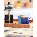 Two coffee mugs on a tray with drip coffee press. 