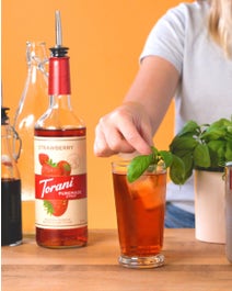 Iced strawberry drink on a table topped with mint.
