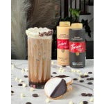 Iced dark chocolate and white chocolate latte on a table with cookies.