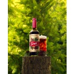 Forest Pine Cold Brew on a tree stump with pine cones and leaves.