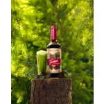 Snow Cap Forest Matcha on a tree stump with pine cones and leaves.